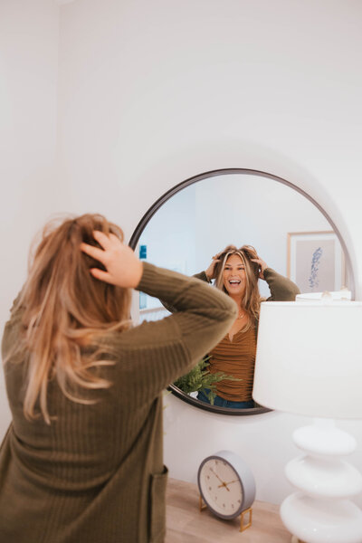 Steph Wagner Wilmington Realtor for Jacie and Co looking in mirror in modern Wilmington house for sale.