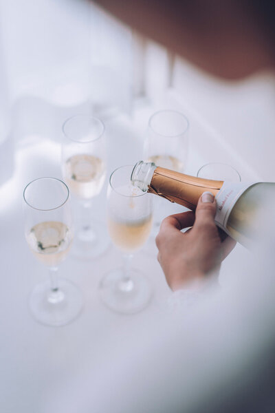 Person pouring champagne into glasses