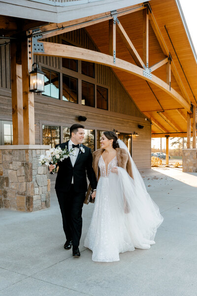 bride and groom walking at black river barn in south haven