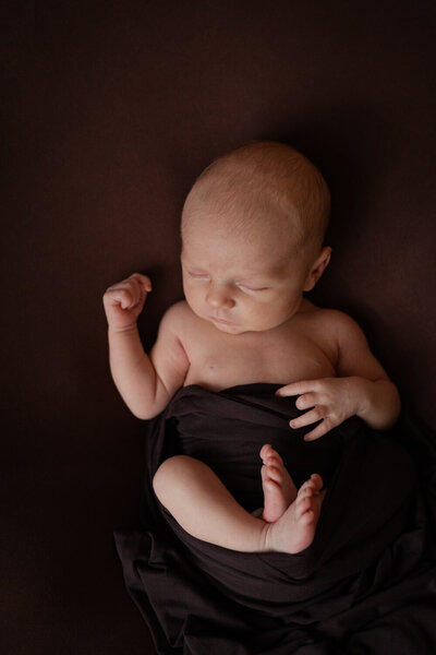 Minimalistische newborn fotoshoot aan huis met een lichte achtergrond. Leg de unieke details van je baby vast in een rustige en natuurlijke omgeving.
