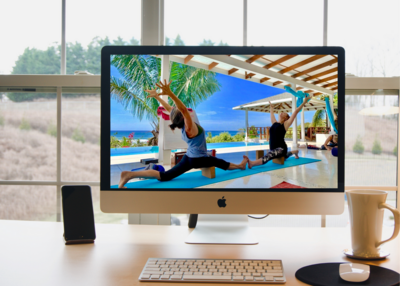 Computer with two yoga instructors teaching on the screen