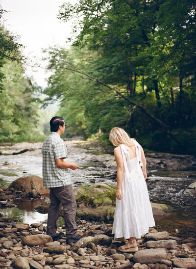 couple looking for rocks in a river bed