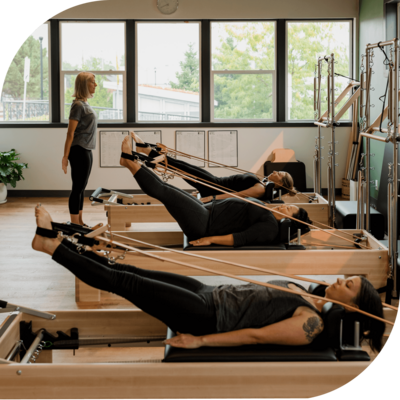 Pilates group equipment class practicing leg circles