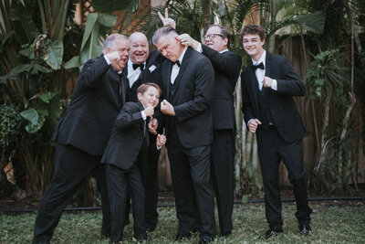 groom and brothers with nephews fun poses before wedding