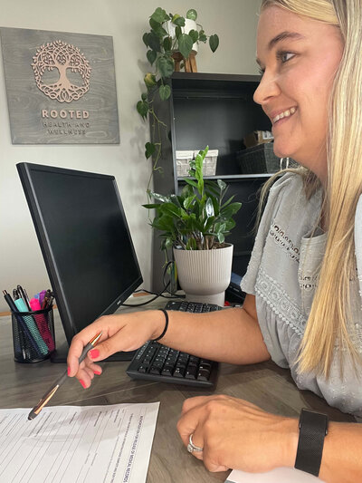 Carlie Johnson in office, speaking with a patient.