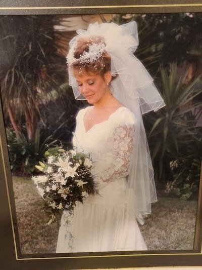 1980's bride wearing a veil and headpiece typical of the 1980's