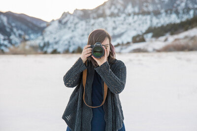 Stephanie, Loveland wedding photographer smiles at the camera in a field of golden rod.