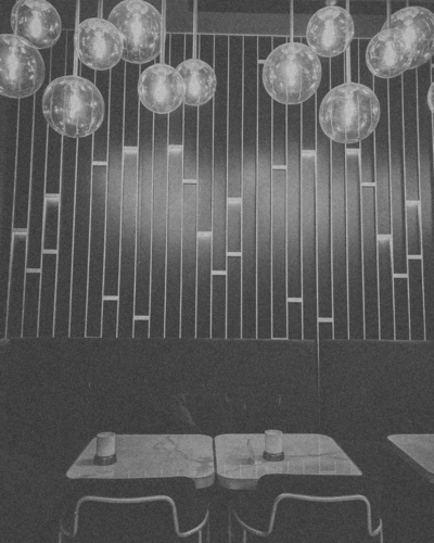 Empty café tables sit under soft hanging lights, reflecting the loneliness and longing explored in the “They Aren’t Choosing Me” Learning Path from CPTSD Medicine.