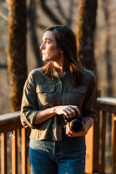 A photo of a woman taking a photo with mountains behind her