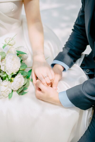 Bride and groom sitting together, holding hands on their wedding day, sharing a quiet and intimate moment in Columbus, OH.