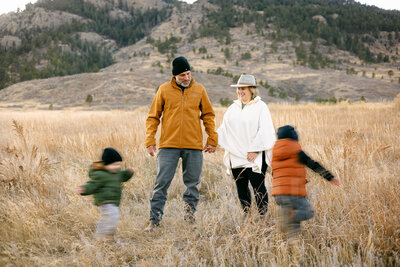 A joyful large family gathers for a fall photo session in Fort Collins, Colorado, surrounded by vibrant autumn leaves.