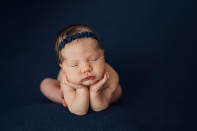 baby girl on navy blue posed at newborn studio in clearwater