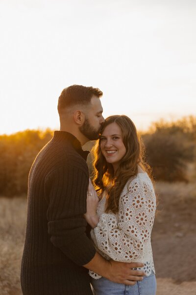 man kisses girls head during couples photo session