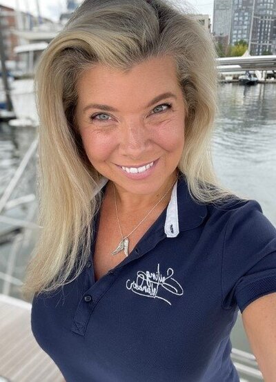 Jessica Gates, owner of Sailing Islander NYC, smiling outside next to the water