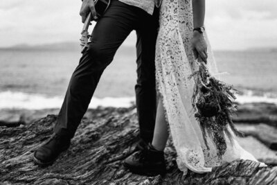 black n white image, closeup of their legs, wearing combat boots, bouquet and holding ukelele