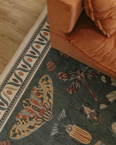 Jewel toned rug with orange couch