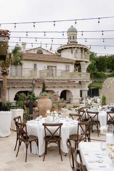 Elegant outdoor wedding reception at Villa Antonia with round tables, white linens, and string lights, planned by Eventive Designs in Austin, Texas.
