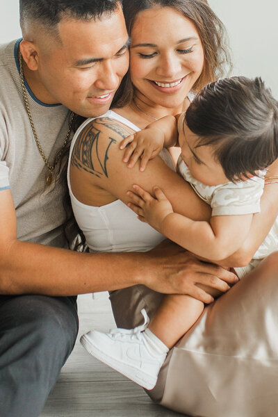 Family with toddler smiling and cuddling together