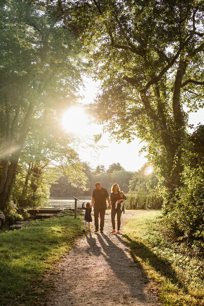 Family of 4 walking on path during family photo session in Sudbury