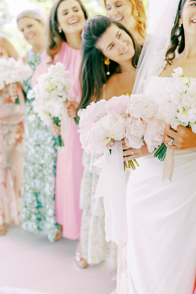 Bridesmaids smile at their bride
