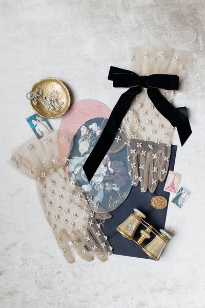 Lace gloves placed on wedding invitations