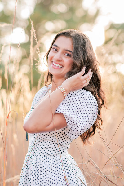girl smiling with her hand on her chin