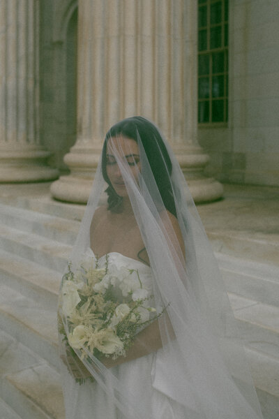 Bride under veil at courthouse