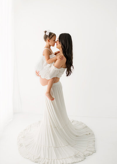 maternity photographer poses pregnant mom on stool holding her bump  for photos