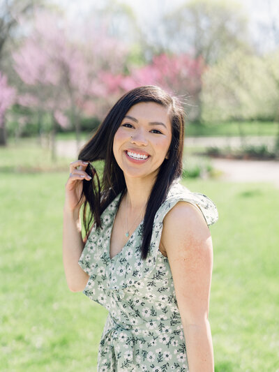 Woman sits on stairs holding camera to smile for her photo