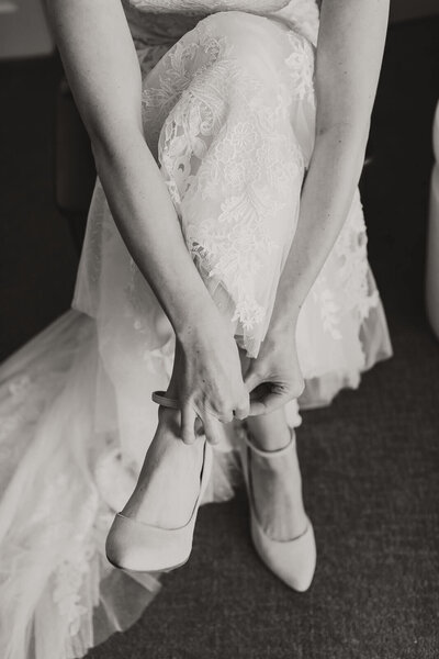 Bride putting on shoes before in getting ready suite