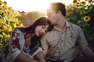 A romantic couple’s portrait at sunset in a sunflower field near Champaign, IL. Light By Zoey Photography captures love and connection in the natural beauty of the Champaign-Urbana region.