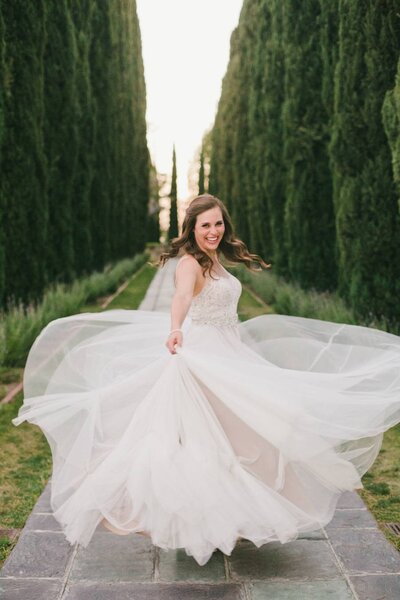 Hollywood bride spinning in dress in garden wedding