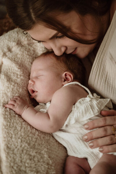 Mama en newborn tijdens newbornshoot in boho setting