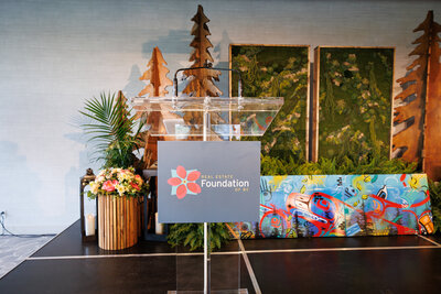 Clear podium with Real Estate Foundation sign on stage with decor.