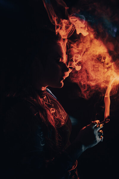 woman smoking with dramatic orange and blue lighting