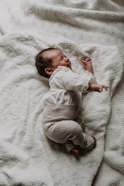 Newborn baby ligt op een kleed