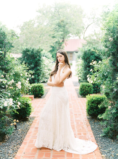 bride in the rose bushes at The Woodbine Mansion in Round Rock, Texas