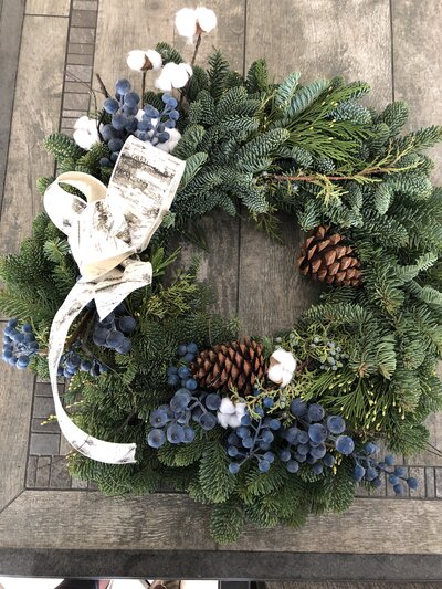 Custom pine wreath with blue berries and pinecoones by Helena's Gardening