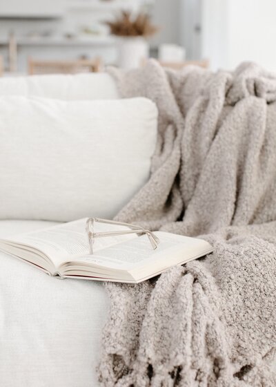 Book open on a blanket on a couch