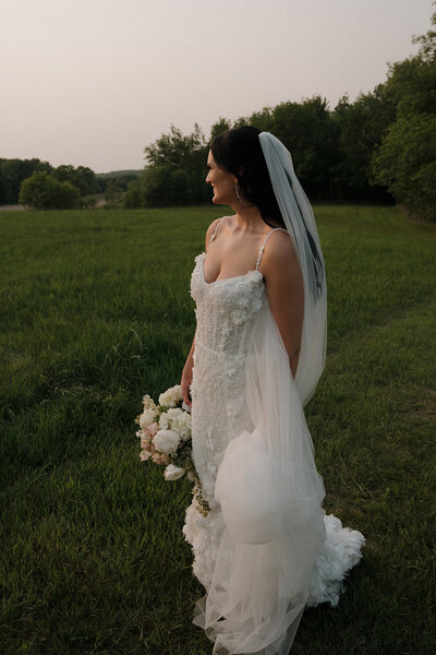 Bride walking alone through a scenic field in Duluth, Minnesota during her wedding photoshoot