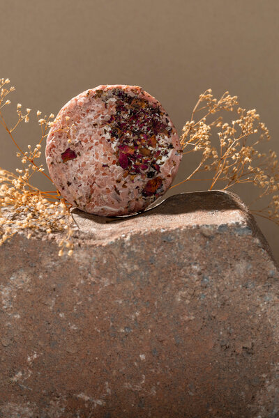 Product photo of pink soap on a rock with rustic florals