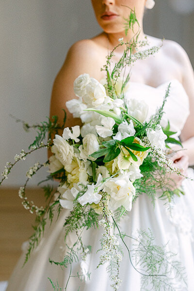 The bride looks elegant in her princess gown. She holds a bouquet of flowers from Studio CK.