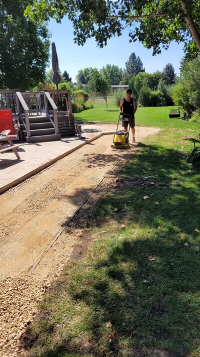 Paver Pros create a level surface for a new patio in a backyard in Missoula, Montana.