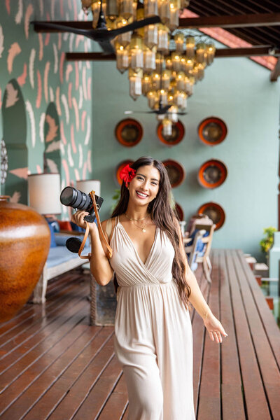 Photographer in Kailua-Kona holding camera indoors