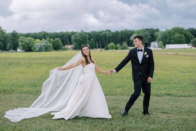 Bride with hair in French braid touching foreheads with groom wearing red rose boutonnière. Bride holding white and rose rose bouquet. Wedding in Northern Virginia captured by Ashley Eagleson Photography.