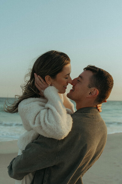 couple looking at each other during beach engagement photos, captured by Elsie Goodman, an NYC engagement and couples photographer