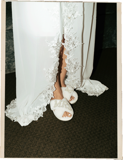 Flash  photograph of a bride's wedding dress and slippers at a wedding in New York