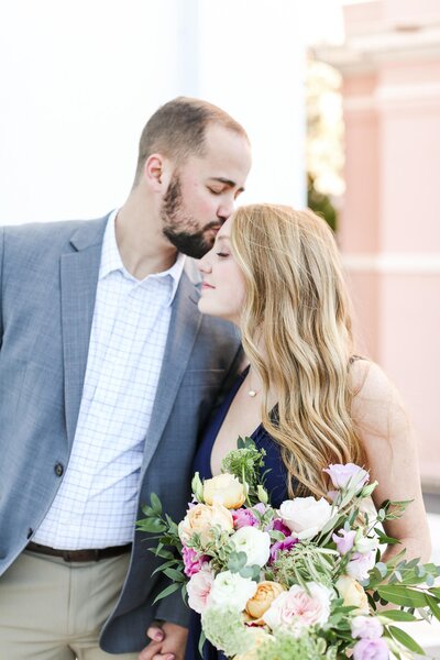 Charleston Rainbow Row engagement photography of couple with gorgeous flowers