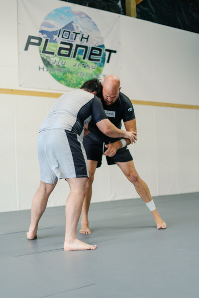 Black belt BJJ athlete engaged in takedown attempt during live sparring in Portland