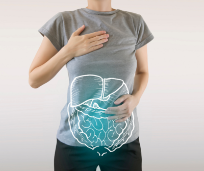woman wearing gray shirt and black pants with one hand on her heart and one hand over her abdomen with liver and intestines outlined on abdomen